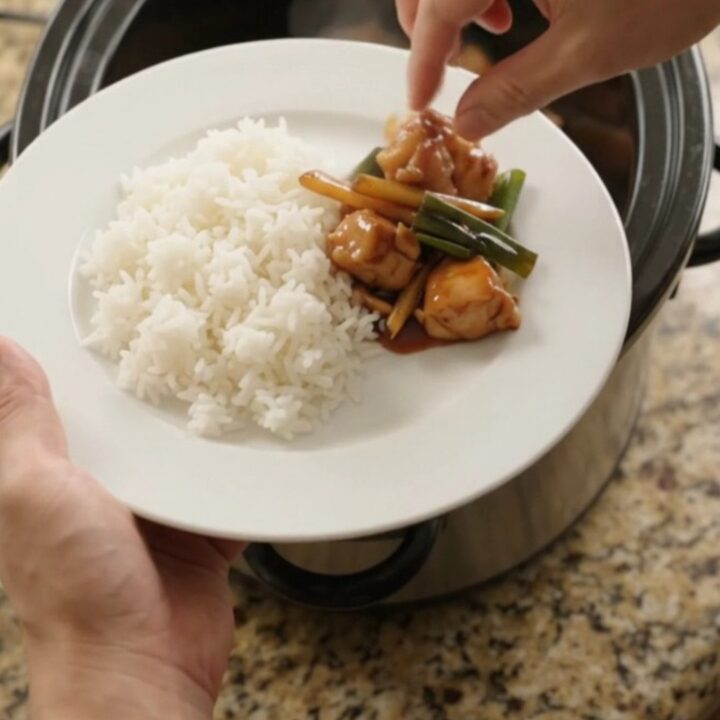 Slow-cooker chicken bites in glossy hickory BBQ sauce with ginger and scallions, served over jasmine rice