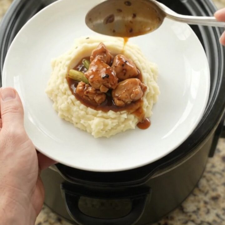 Glazed chicken bites in a slow cooker with ginger and scallions, glossy bourbon sauce