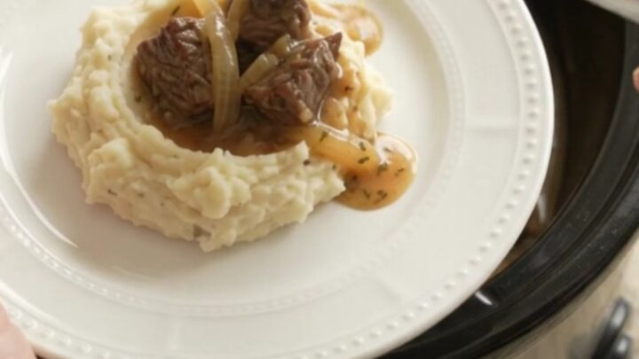 Bubbling crockpot of beef bites and onions in golden au jus