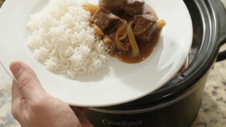 Slow cooker beef and onions in rich bourbon gravy, topped with butter pats