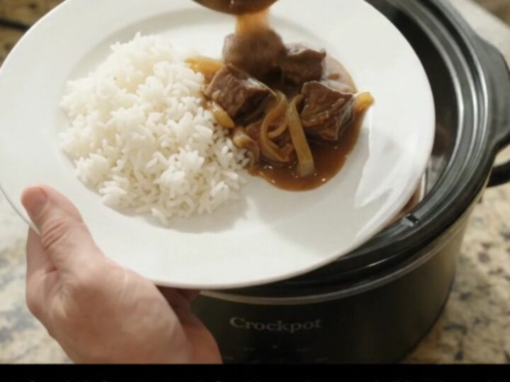 Slow cooker beef and onions in rich bourbon gravy, topped with butter pats