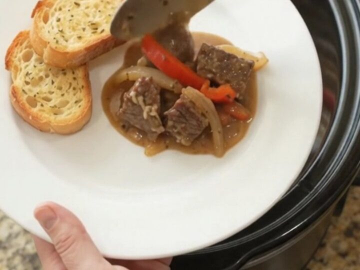 Slow cooker beef with creamy Gruyère sauce and peppers in a black crockpot