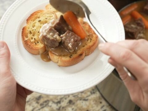 Slow cooker beef with carrots and potatoes in creamy Gruyère sauce, garnished with parsley