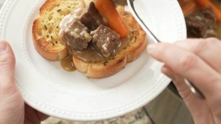 Slow cooker beef with carrots and potatoes in creamy Gruyère sauce, garnished with parsley
