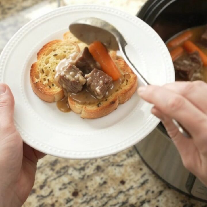 Slow cooker beef with carrots and potatoes in creamy Gruyère sauce, garnished with parsley