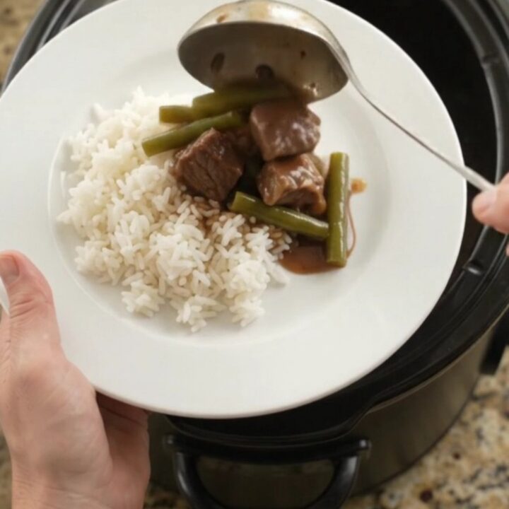 Slow cooker filled with beef, green beans, and potatoes in bourbon gravy
