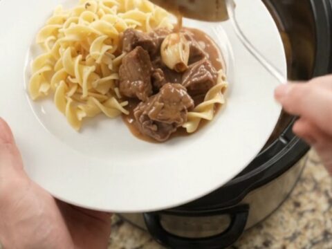 Slow cooker filled with sirloin tips and baby potatoes in a creamy brown gravy