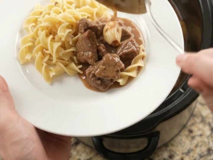 Slow cooker filled with sirloin tips and baby potatoes in a creamy brown gravy
