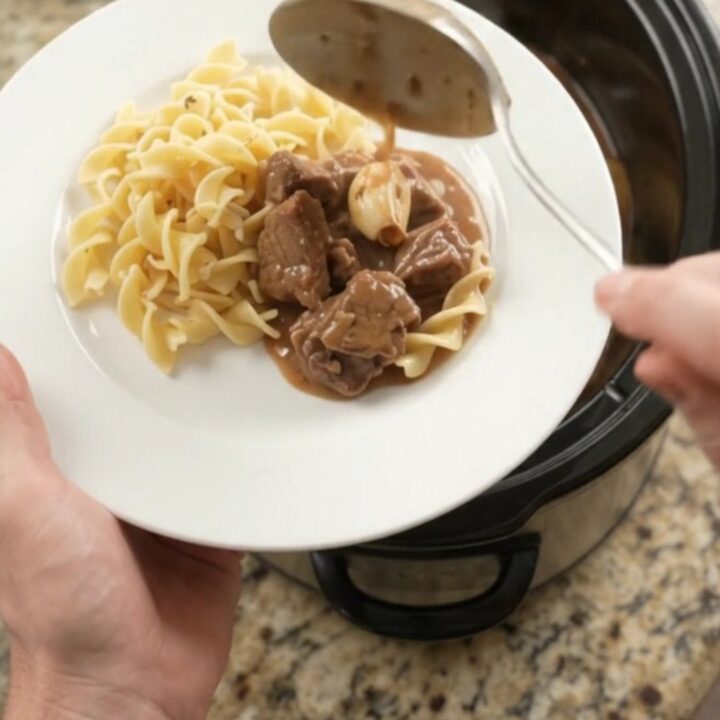 Slow cooker filled with sirloin tips and baby potatoes in a creamy brown gravy