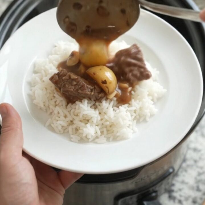 Slow-cooker sirloin tips and potatoes in bourbon gravy in a black crockpot