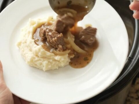 Slow-cooker sirloin tips and caramelized onions in a rich butter au jus, served in a black crockpot