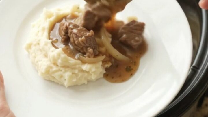 Slow-cooker sirloin tips and caramelized onions in a rich butter au jus, served in a black crockpot