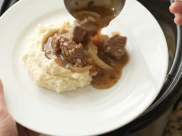 Slow-cooker sirloin tips and caramelized onions in a rich butter au jus, served in a black crockpot