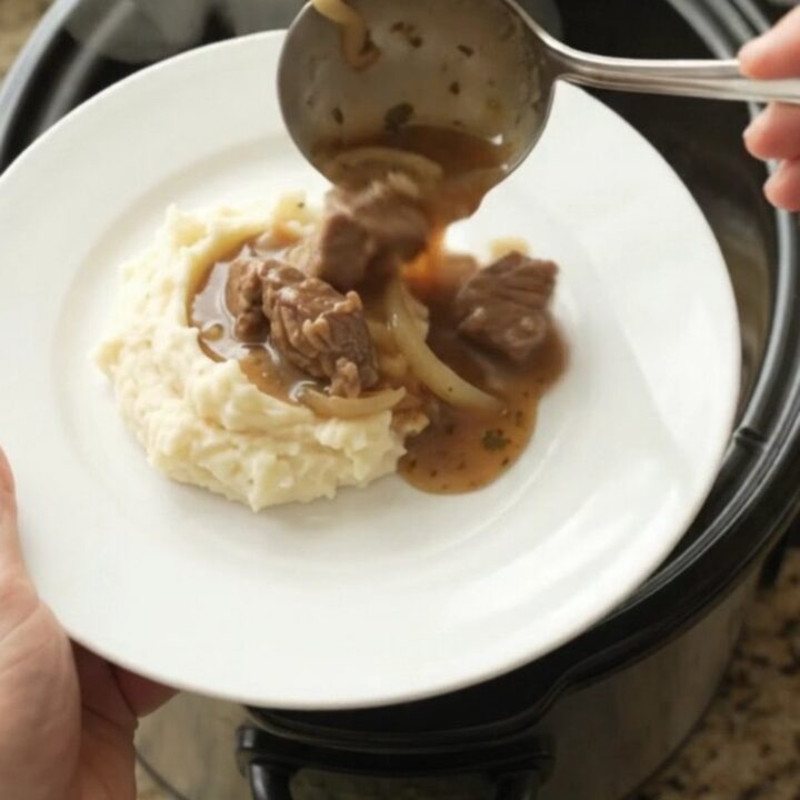 Slow-cooker sirloin tips and caramelized onions in a rich butter au jus, served in a black crockpot