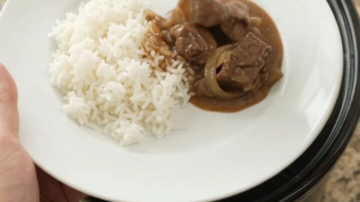 Slow cooker filled with tender sirloin tips and onions in rich bourbon gravy