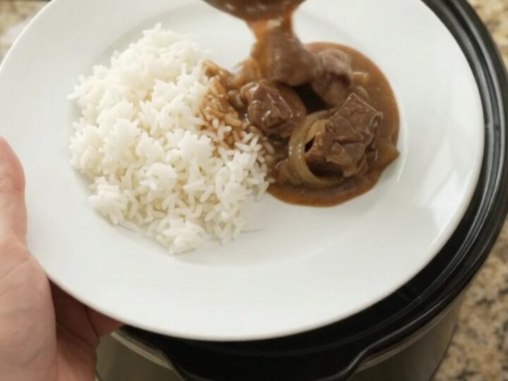 Slow cooker filled with tender sirloin tips and onions in rich bourbon gravy