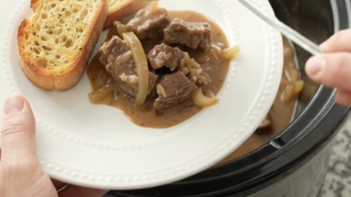 Slow cooker filled with tender sirloin tips and onions in a creamy Gruyère sauce