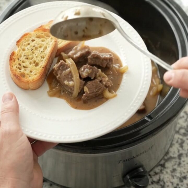 Slow cooker filled with tender sirloin tips and onions in a creamy Gruyère sauce