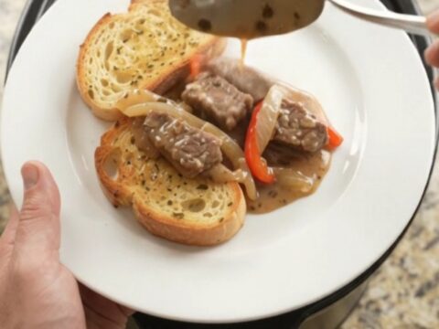Slow cooker sirloin tips in creamy Gruyère sauce with peppers and onions, served on toasted brioche