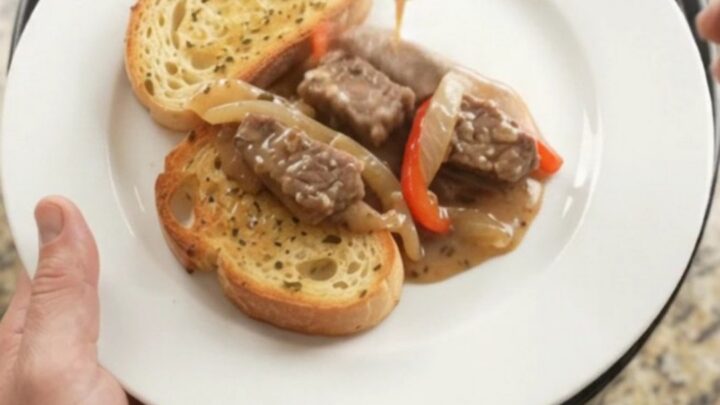 Slow cooker sirloin tips in creamy Gruyère sauce with peppers and onions, served on toasted brioche
