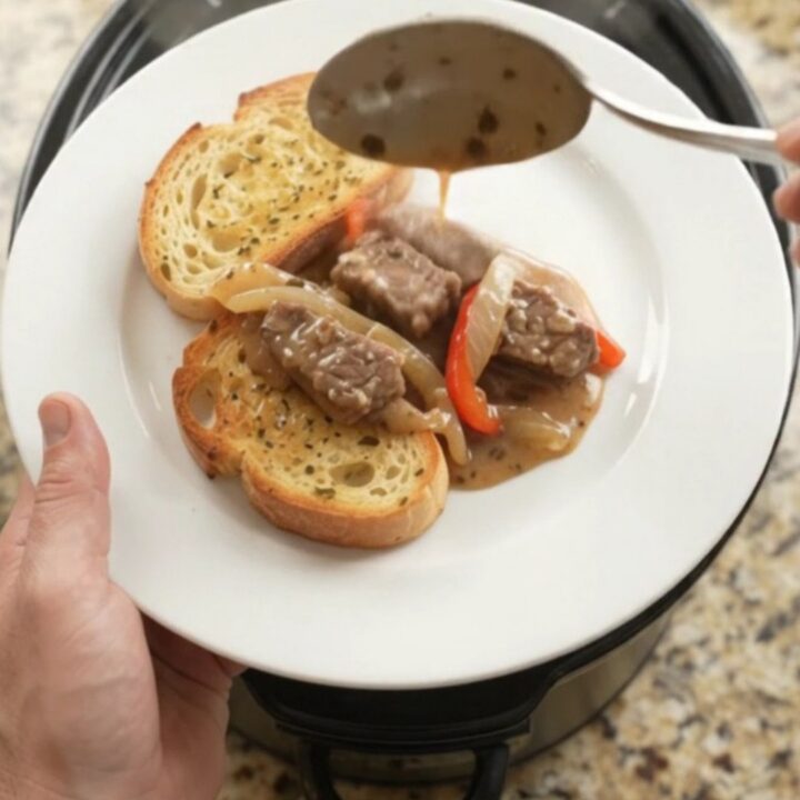 Slow cooker sirloin tips in creamy Gruyère sauce with peppers and onions, served on toasted brioche