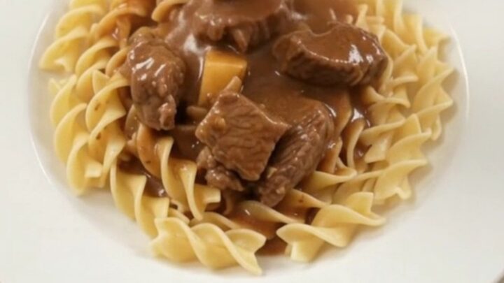 Slow cooker full of sirloin tips, green beans, and potatoes in a creamy brown gravy