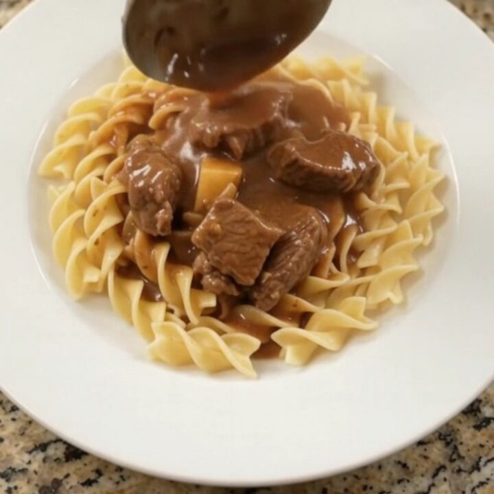 Slow cooker full of sirloin tips, green beans, and potatoes in a creamy brown gravy