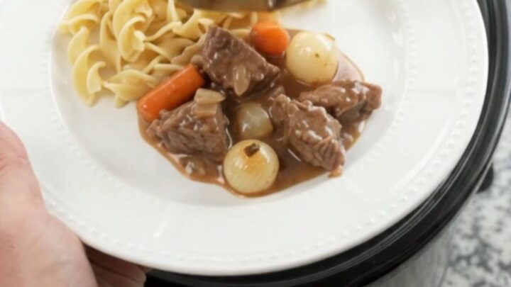 Tender sirloin tips in creamy sour cream gravy with pearl onions and carrots in a slow cooker