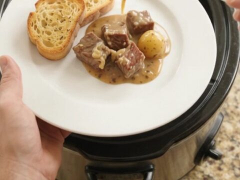 Crockpot ribeye bites and potatoes in creamy Gruyère sauce, ready to serve