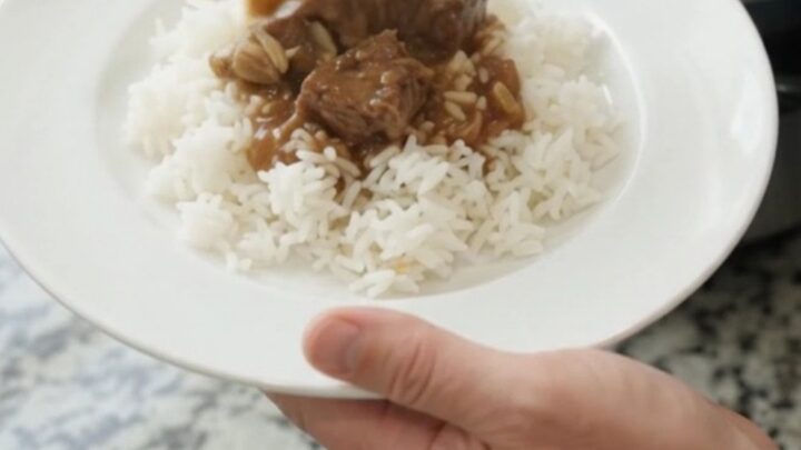 Slow cooker filled with ribeye bites and baby potatoes in a rich bourbon gravy, topped with butter pats.