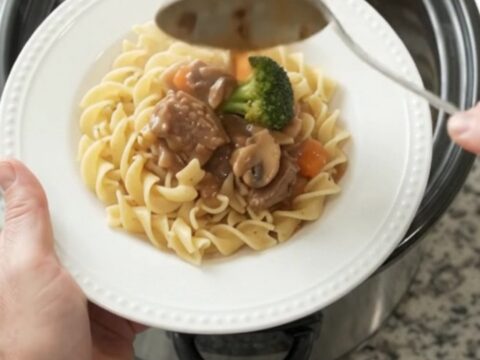 Slow cooker sour cream broccoli ribeye bites with gravy in a black crockpot