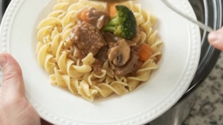 Slow cooker sour cream broccoli ribeye bites with gravy in a black crockpot