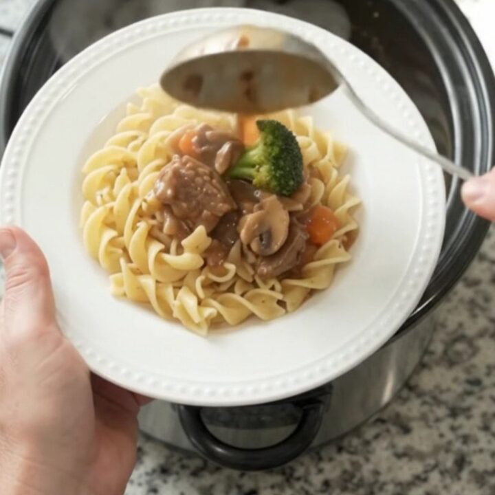 Slow cooker sour cream broccoli ribeye bites with gravy in a black crockpot