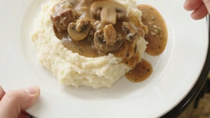 Slow cooker filled with ribeye bites, broccoli, and mushrooms in a buttery au jus sauce.