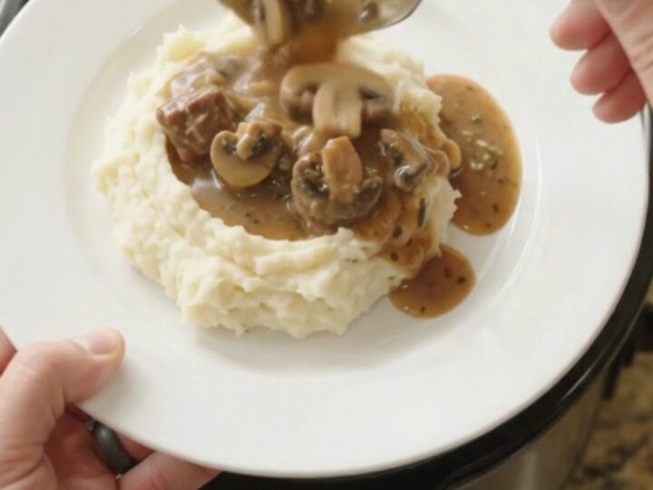 Slow cooker filled with ribeye bites, broccoli, and mushrooms in a buttery au jus sauce.