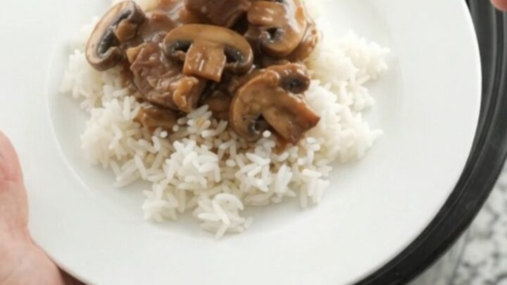 Bourbon gravy portobello ribeye bites in a slow cooker, topped with butter pats