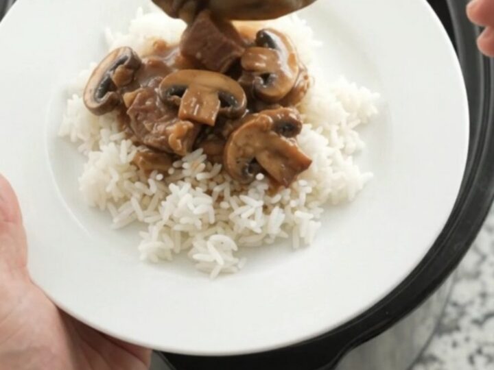 Bourbon gravy portobello ribeye bites in a slow cooker, topped with butter pats