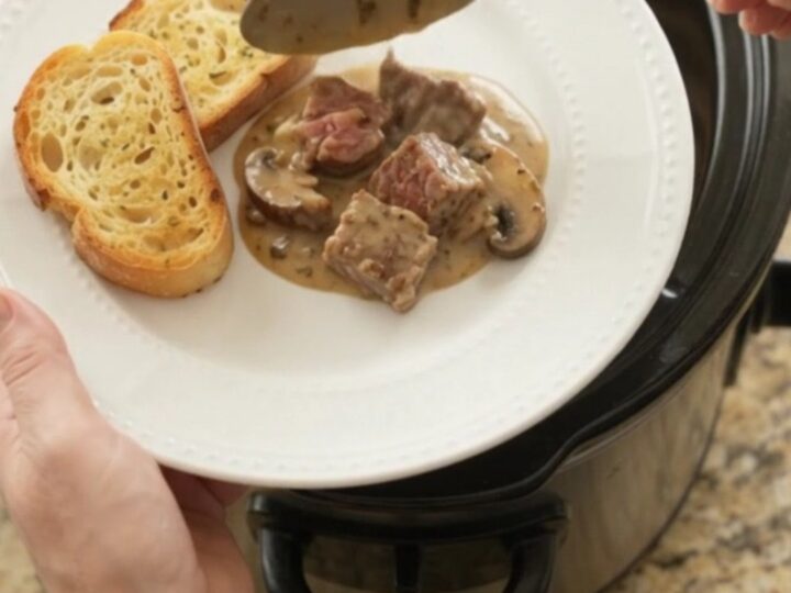 Crockpot ribeye bites with portobello mushrooms and shallots in a creamy Gruyère sauce, served on toasted brioche