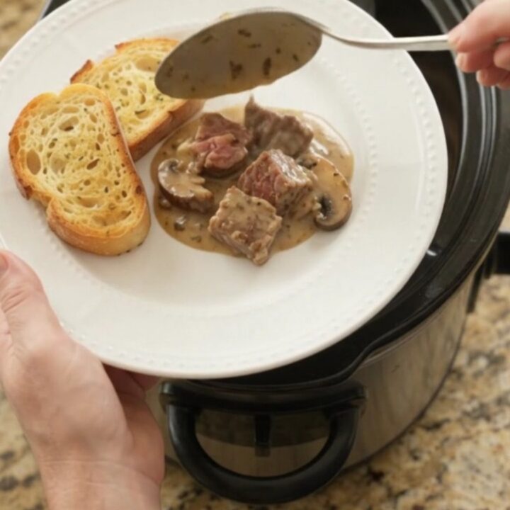 Crockpot ribeye bites with portobello mushrooms and shallots in a creamy Gruyère sauce, served on toasted brioche