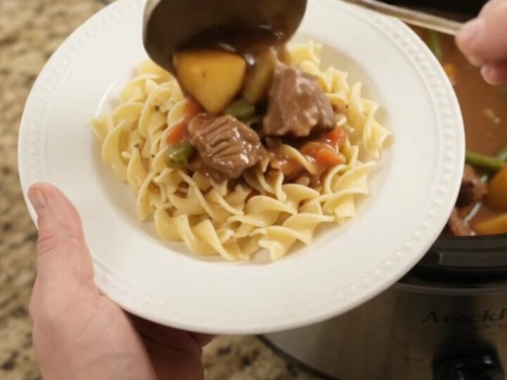 Slow cooker filled with tender ribeye bites, green beans, and potatoes in a creamy gravy