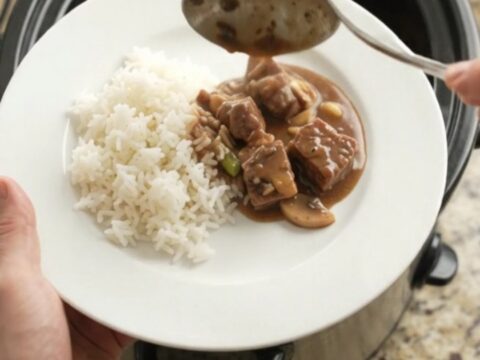 Slow cooker bourbon gravy ribeye bites with asparagus in a glossy dark sauce