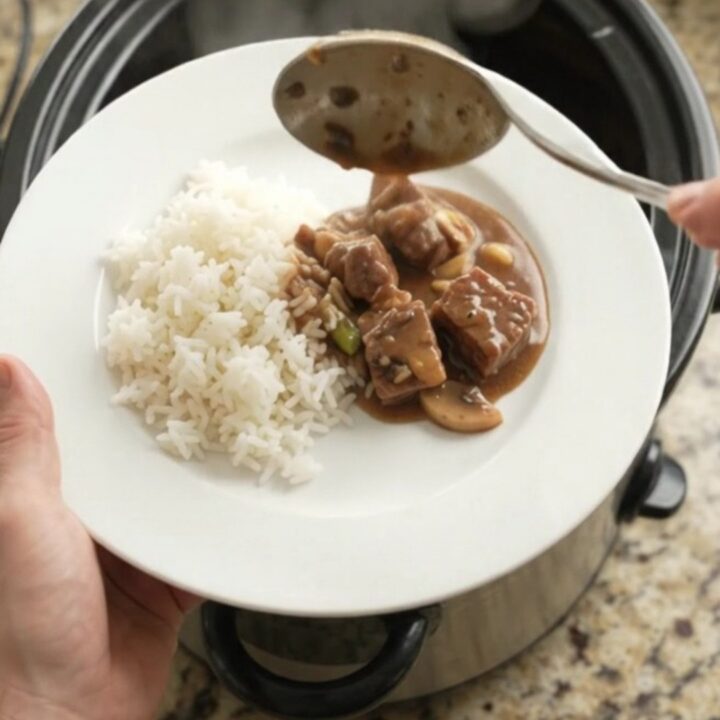 Slow cooker bourbon gravy ribeye bites with asparagus in a glossy dark sauce