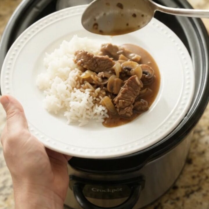 Tender flank steak strips in bourbon-mushroom gravy with mushrooms and onions in a slow cooker