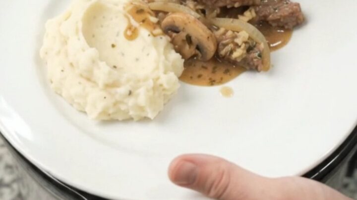 Cowboy butter mushroom flank steak in a slow cooker, bubbling in rich gravy