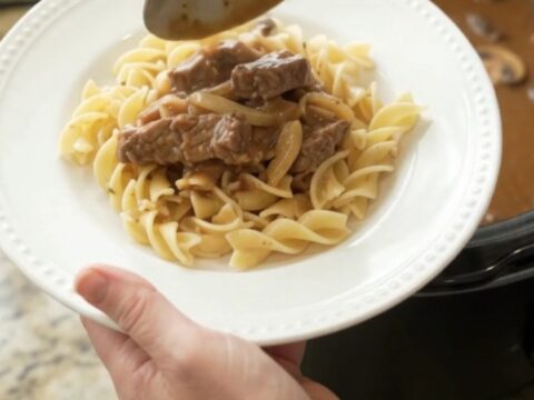Slow cooker flank steak in creamy mushroom gravy with onions