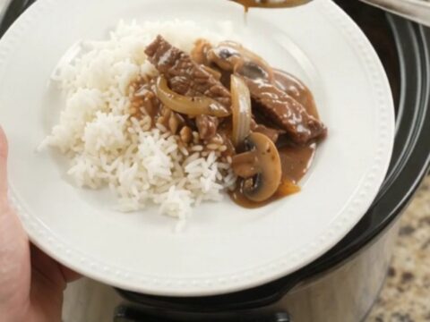 Tender flank steak strips and bell peppers in glossy bourbon gravy in a Crockpot