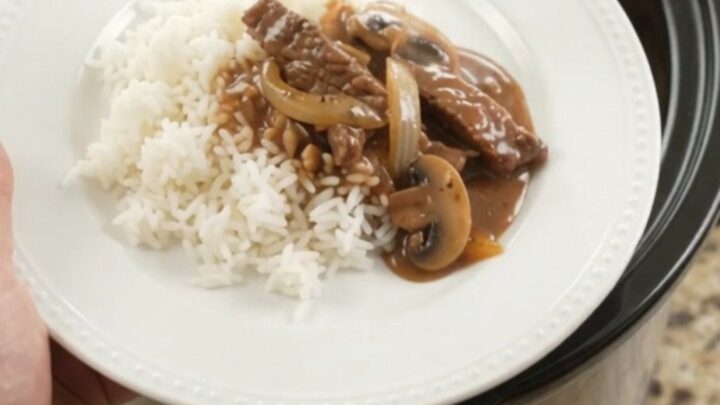 Tender flank steak strips and bell peppers in glossy bourbon gravy in a Crockpot