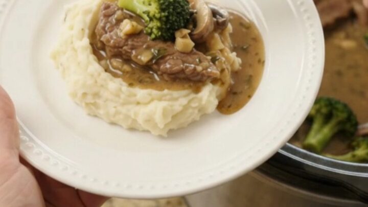 Slow cooker filled with tender flank steak strips, broccoli florets
