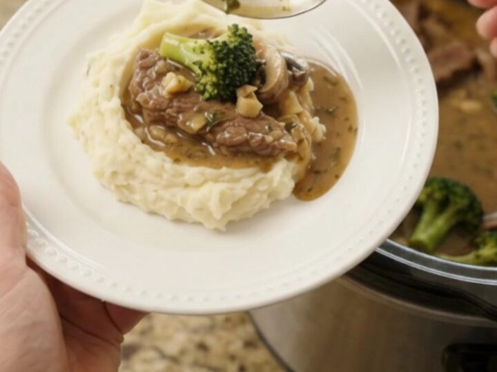 Slow cooker filled with tender flank steak strips, broccoli florets