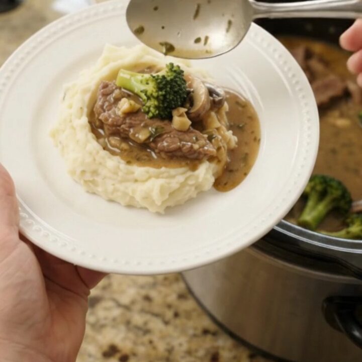 Slow cooker filled with tender flank steak strips, broccoli florets